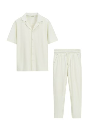 Chemise à manches courtes à boutons et pantalon à taille élastique avec cordon de serrage en tissu côtelé crème clair.
