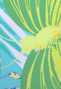 Bloemmotiefstof met levendige groene en blauwe kleuren, met een gestructureerde weving en een zachte oppervlakte, waarin gele accenten en abstracte ontwerpen zijn verwerkt.