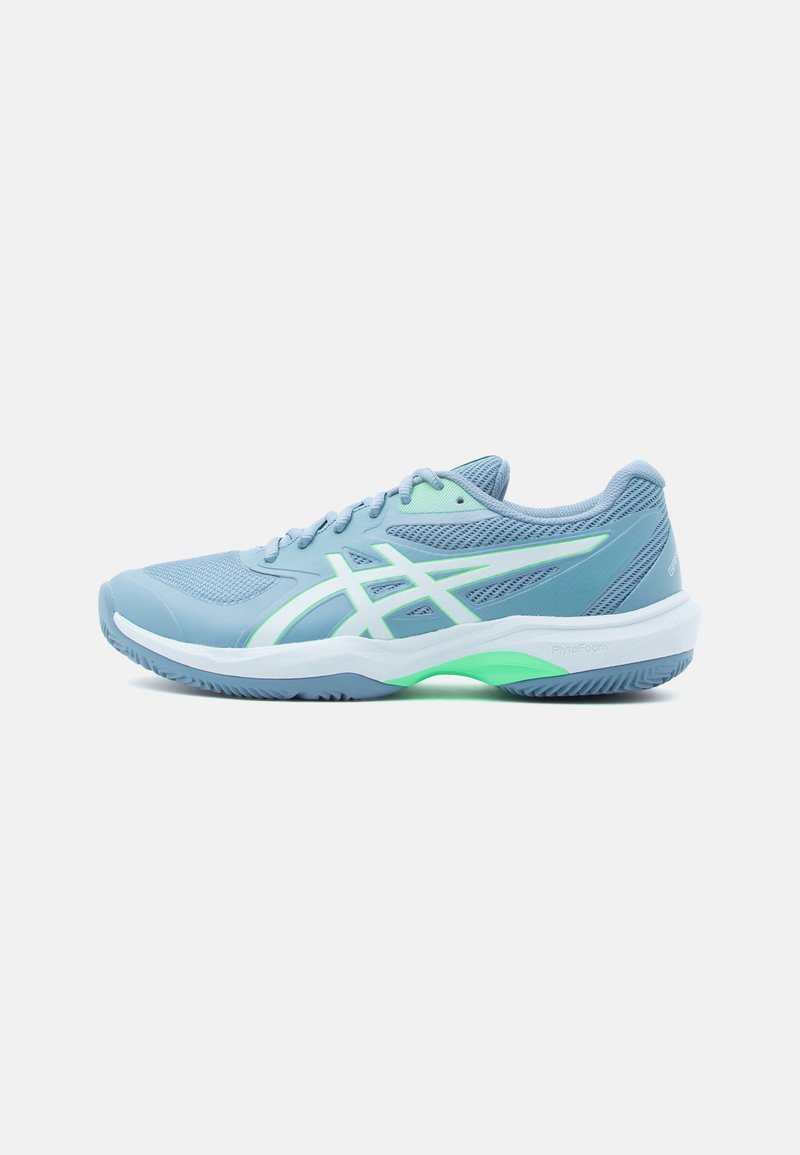 Chaussure de sport bleu clair en tissu mesh, avec une semelle blanche et des accents verts. Présente un design élégant et un logo contrastant sur le côté.