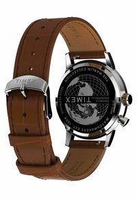 Zegarek Timex z stalową kopertą, czarną tarczą z mapą świata oraz brązowym skórzanym paskiem z tłoczeniem i srebrną klamrą.