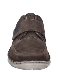 Brown suede shoe with a Velcro strap, rounded toe, and contrasting stitching, featuring a textured panel on the upper. Flat, rubber sole.
