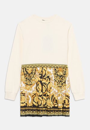 Sweatshirt de mangas compridas em creme com um padrão floral em preto e dourado na parte inferior, apresentando designs intricados e acentos dourados.