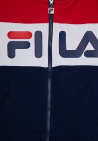 Felpa con zip rossa, bianca e blu navy con grande logo "FILA", dotata di una robusta zip, tasche frontali e polsini e orlo a costine.