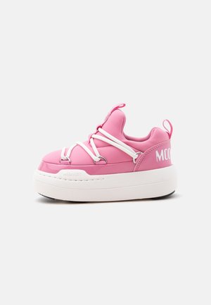 Zapatilla deportiva de plataforma rosa con suela blanca gruesa, ojales blancos cruzando la parte superior y tiradores en la lengüeta y el talón.