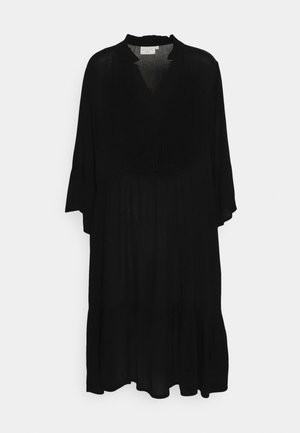 Schwarzes Kleid mit V-Ausschnitt und Rüschensaum. Ausgestellte Ärmel, lässige Passform und fließender Saum. Hergestellt aus leichtem, transparentem Stoff.