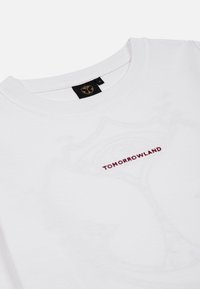 Witte katoenen t-shirt met een ronde halslijn, voorzien van maroon "TOMORROWLAND" tekst op de voorkant en een logotag op de achterkant van de kraag.