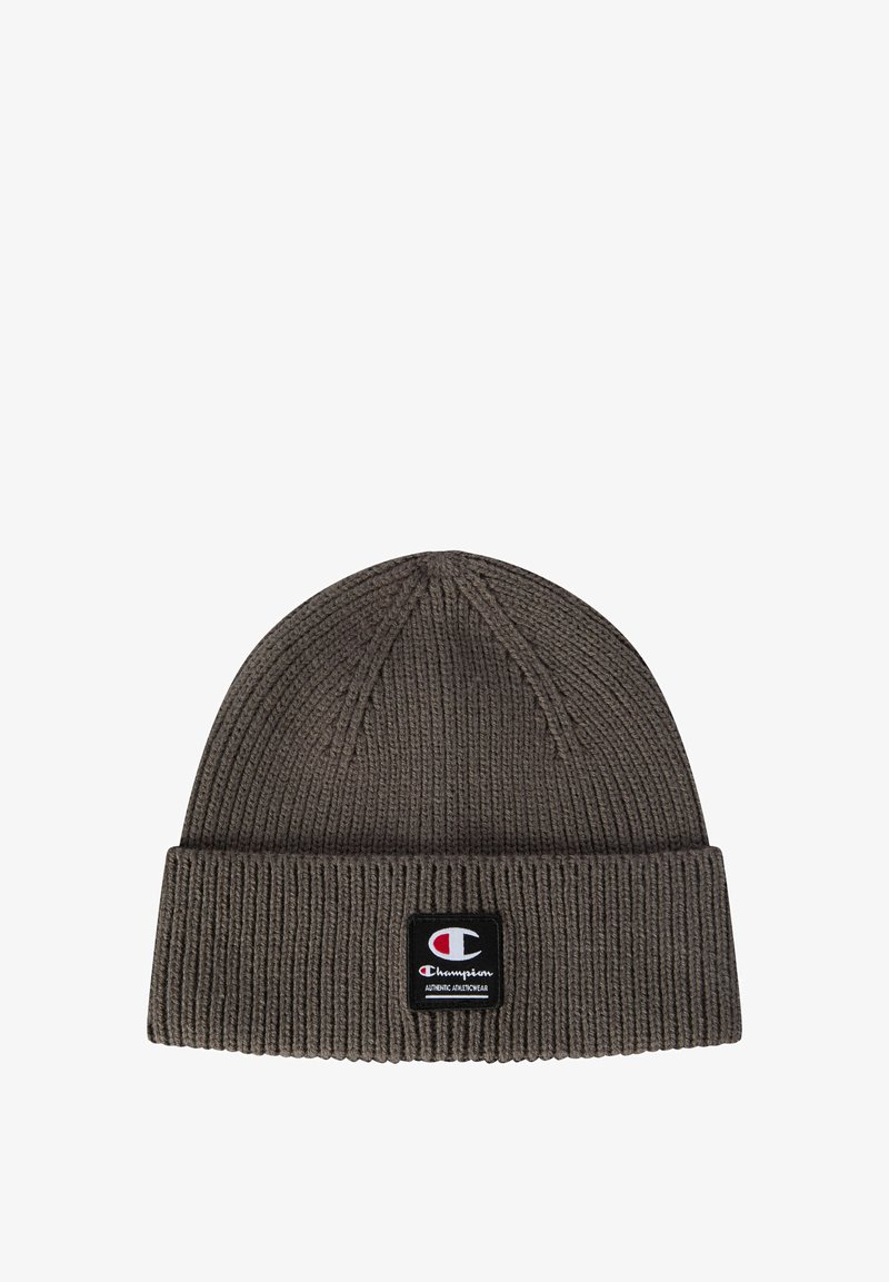 Brown knitted beanie hat with a folded cuff and a rectangular logo patch featuring red, white, and black colors. Textured ribbing detail throughout.