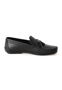 Zwarte leren moccasinschoen met een plat ontwerp, versierd met een decoratieve kwast, handgestikte details en een rubberen zool.