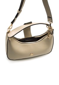 Bolso de mano de cuero beige con forma redondeada, acentos negros, herrajes dorados, una sola correa y bolsillo con cremallera. Textura suave con costuras en contraste.