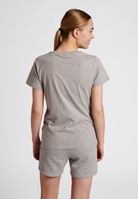 Grå bomullströja med korta ärmar, i kombination med matchande grå shorts. Tyget har en slät textur och en avslappnad passform.