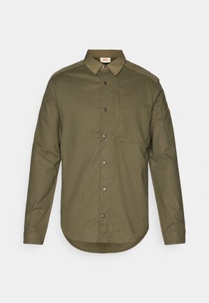 Olive green button-up shirt with a collar, long sleeves, and a front pocket. Features silver buttons and a rounded hem. Textured fabric.