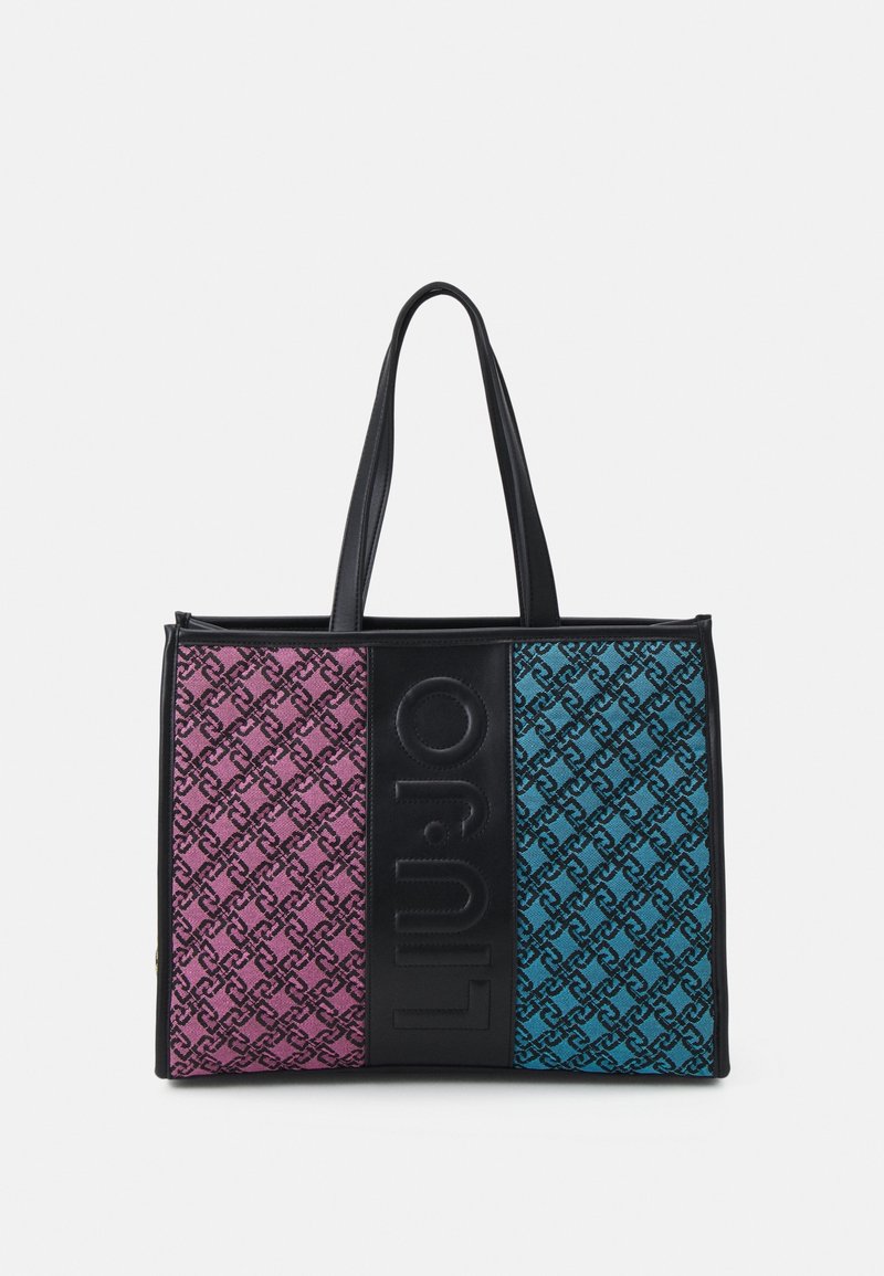 Tote bag met een levendig ontwerp in roze en turquoise, textiel met structuur en een zwart logo paneel, en stevige zwarte handvatten.