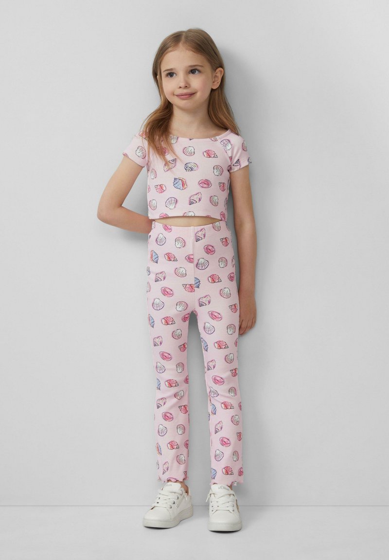 Zweiteiliges Outfit für Kinder mit einem kurzärmligen Cropped-Top und Leggings, beide in zartem Rosa mit Muschelmuster. Weicher Stoff, taillierte Form.