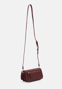 Borsa crossbody bordeaux con una texture liscia, dotata di una tasca con zip, una sottile tracolla regolabile e una forma rettangolare compatta.