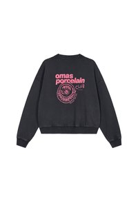 Čierna mikina s opadanými ramenami, rebrovanými manžetami a lemom. Na zadnej strane má ružový grafický nápis a ilustráciu zobrazujúcu porcelánový dizajn.
