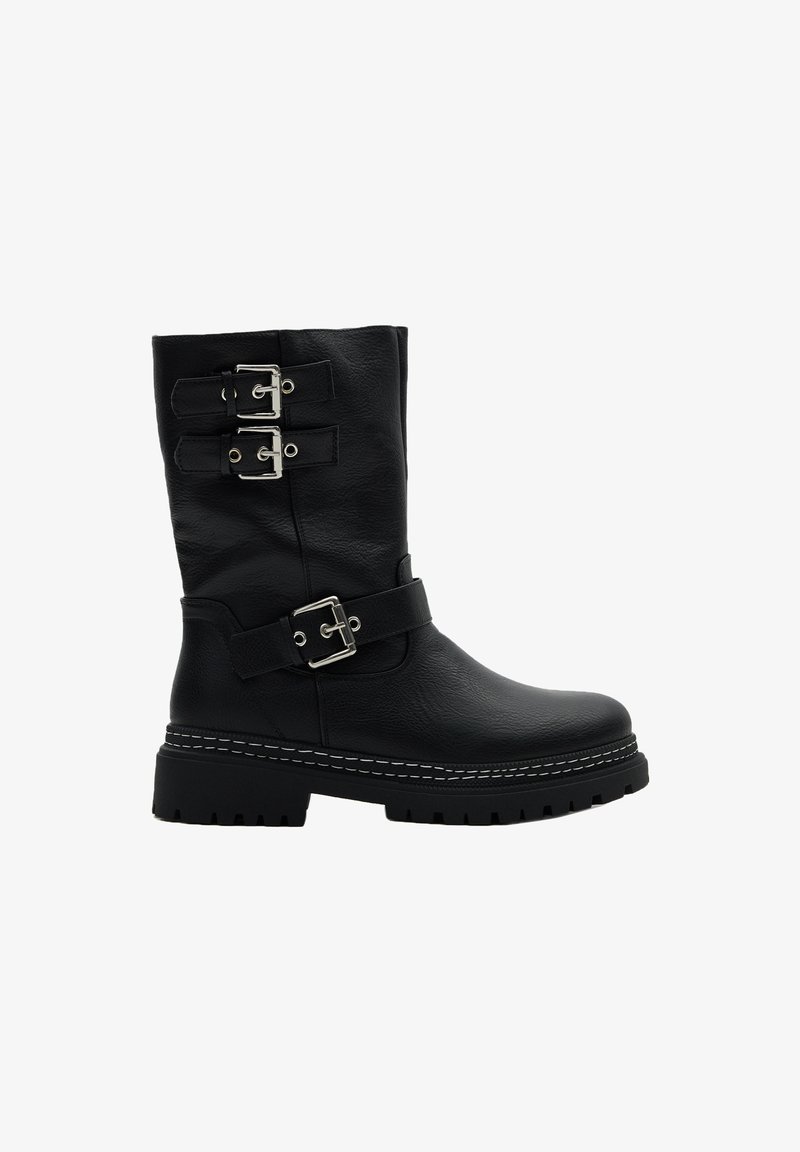 Botas de cuero negro hasta la rodilla con dos hebillas y correas plateadas, acabado texturizado, suela gruesa y costuras blancas contrastantes.
