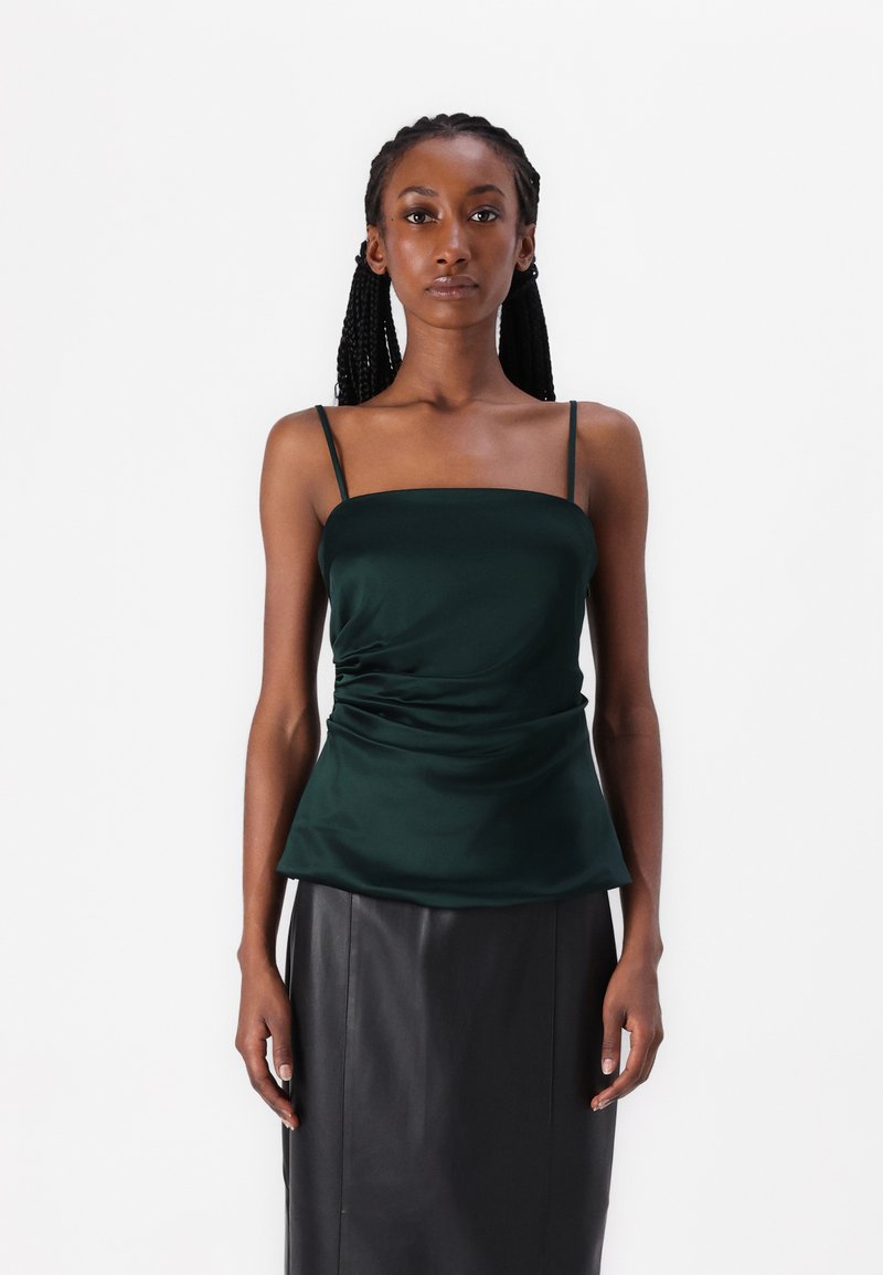 Emerald green satin tank top with adjustable spaghetti straps, featuring a square neckline and gathered texture at the waist.
