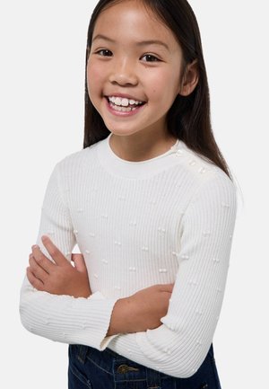 Pull long à manches longues blanc en côtes avec des points texturés. Dispose d'un col rond et d'accents à boutons sur l'épaule. Le tissu semble doux.