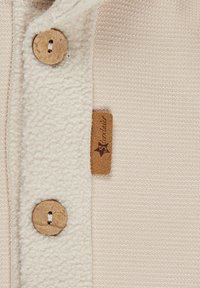 Light beige pullover featuring a soft fleece collar, wooden buttons, and a brown leather tab with the brand name.