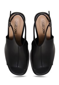 Paire de sandales en cuir noir à bout ouvert avec bride arrière et semelles beiges de la marque Cesare Gaspari, vue de dessus sur fond blanc.