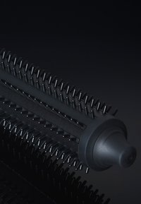 Zwarte cilindrische haarstylingsborstel met fijne borstelharen, een gestructureerde grip en een tapse punt; ontworpen voor het gladstrijken en stylen van haar.