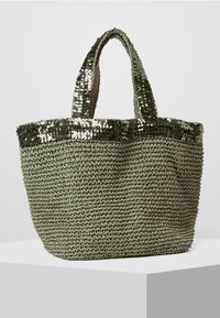 Green woven tote bag with a textured body and shiny sequin accents along the top edge. Features two sturdy handles for easy carrying.