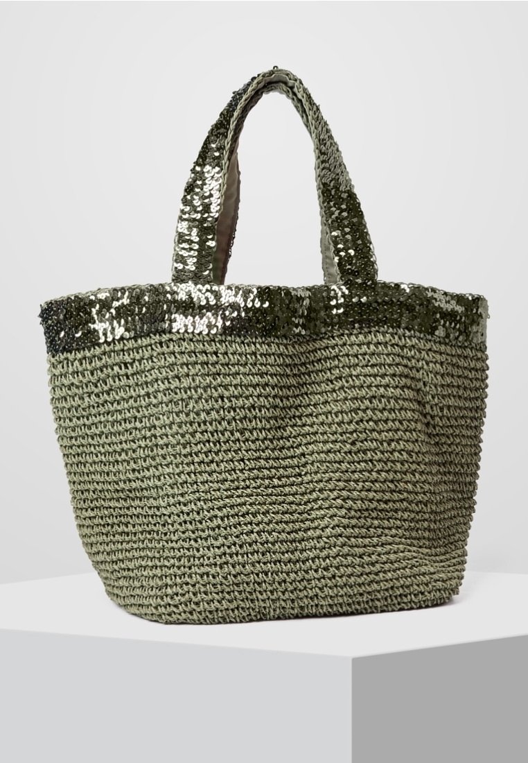 Green woven tote bag with a textured body and shiny sequin accents along the top edge. Features two sturdy handles for easy carrying.
