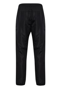 Schwarze Hose mit einer glatten, glänzenden Oberfläche, elastischem Bund und schmal zulaufenden Beinen mit elastischen Bündchen an den Knöcheln.