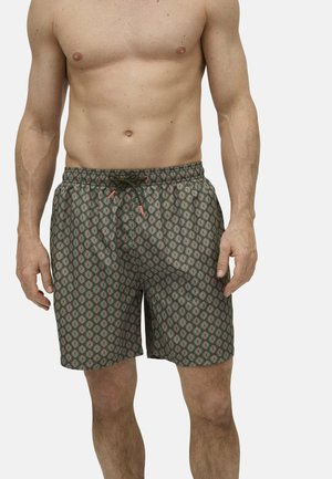 Bañadores de hombre en verde con un patrón geométrico en rojo y beige, con cintura elástica y cordón para un ajuste ajustable.