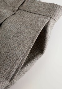 Wollmischungshose aus einem strukturierten grauen Stoff mit dezenten braunen Sprenkeln, ausgestattet mit einem maßgeschneiderten Schnitt und klaren, strukturierten Linien.
