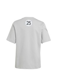 Camiseta de manga corta gris claro con un parche blanco redondo con el número 25 en la parte trasera y sutiles detalles de líneas horizontales en las mangas.
