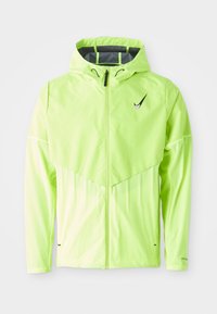 Giacca leggera verde neon con cappuccio, cerniera a full zip e interno grigio a contrasto. Presenta un design a cuciture diagonali e un logo nero.