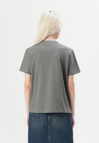 T-shirt gris à manches courtes en mélange de coton doux, avec un col rond classique et une coupe décontractée. La vue arrière présente une texture lisse.