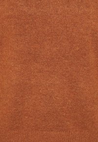 Stickad tröja i en djup rostfärg, med ett mjukt, texturerat tyg. Enkla design med ett subtilt, konsekvent mönster genom hela.