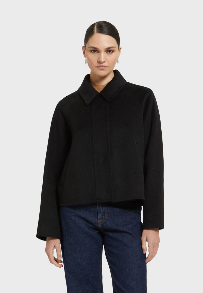 Čierna skrátená bunda s veľkým golierom, dlhými rukávmi a hladkou textúrou. Obsahuje skrytý predný zapínanie a minimalistický dizajn.