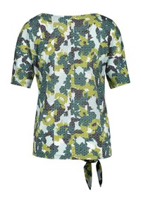 Top de manga corta con un patrón floral en tonos azul claro, verde y gris, con un cierre de botón en la parte posterior y un detalle atado en el dobladillo.