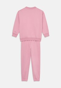 Rosa Jogginganzug bestehend aus einem Sweatshirt mit Rundhalsausschnitt und taillierten Jogginghosen. Hergestellt aus weichem Material mit elastischen Bündchen und einem elastischen Bund.