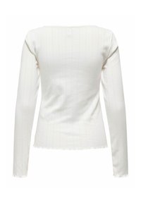 Haut blanc à manches longues en tissu côtelé texturé, avec un col rond et uneourlet légèrement court aux bords bruts.