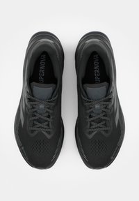 Paar schwarze Laufschuhe mit Schnürsenkeln, atmungsaktivem Mesh-Obermaterial und "Gore-Tex" Branding an den vorderen Außenseiten.