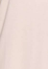 Light pink cotton fabric with a smooth texture, featuring a subtle, even grain pattern. No visible hardware or accents.