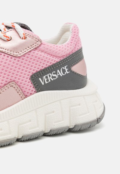 Sneaker in rete rosa con accenti grigi, contrassegnata con "VERSACE". Presenta una suola testurizzata e lacci a contrasto per un dettaglio migliorato.