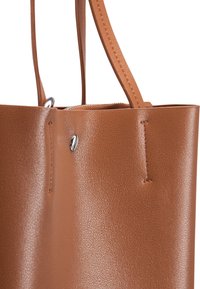 Borsa tote in pelle marrone con una texture liscia, dotata di apertura in alto, dettagli in metallo argentato e cuciture rinforzate.