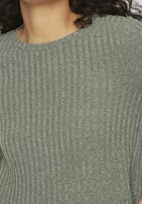 Pull gris en maille côtelée avec un col rond et une finition texturée, mettant en valeur les lignes verticales sur tout le tissu.