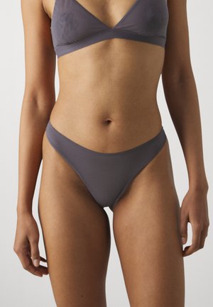 Grijze bralette en bijpassende bikini onderkant set, gemaakt van gladde stof met een subtiele glans. Het ontwerp heeft een driehoekige top en minimale bedekking.