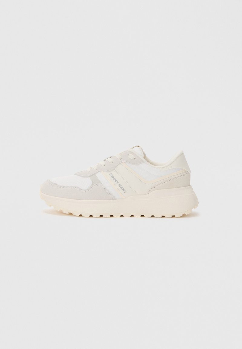 Baskets blanches et beige clair avec un mélange de tissus lisses et texturés. Dotées d'une semelle rembourrée et d'un accent logo sur le côté.