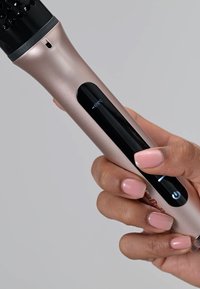 Uno strumento per acconciare i capelli color oro rosa con un manico nero. Presenta un display digitale che mostra 175°C e un pulsante di accensione sul manico.