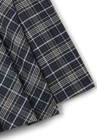 Tessuto blu scuro con un motivo a quadri. Presenta linee bianche e beige che formano quadrati e rettangoli. Texture liscia, si drappeggia dolcemente.