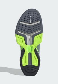 La semelle de la chaussure présente un design en caoutchouc gris et noir avec des accents vert lime, texturée pour une meilleure adhérence, arborant le logo "Continental".