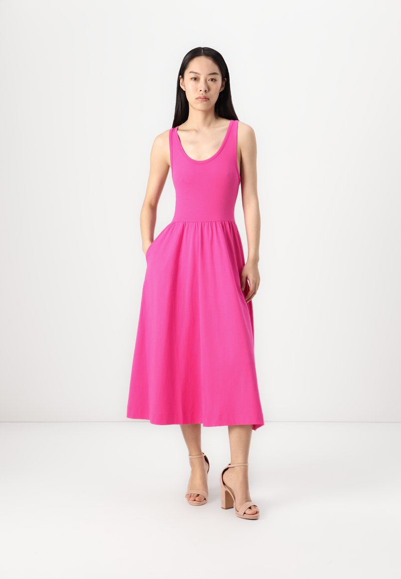 Rosa ärmelloses Kleid mit tailliertem Oberteil und weit ausgestellt Rock, aus weichem Stoff gefertigt. Verfügt über seitliche Taschen und einen knielangen Saum.
