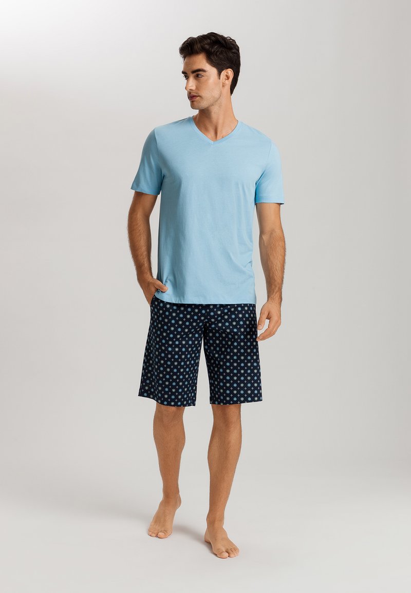 Light blue short-sleeve V-neck t-shirt paired with dark blue shorts featuring a small floral pattern. Material is soft and lightweight.